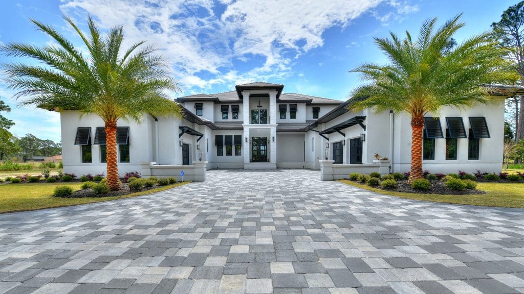 Patel home front view with brick driveway and black window features designed & constructed by Rita Jones Construction in Panama City Beach Florida